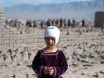 An injured Afghan girl stands near damaged houses at the site of an overnight Pakistan airstrike. Afghan authorities said on March 13 that Pakistan had carried out new strikes on Kabul and border provinces.