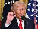 Donald Trump gestures as he speaks during a Women's Month History event in the East Room of the White House