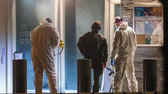 TOPSHOT - Forensic experts and a police officer stand in front the entrance of the US embassy after a loud bang was reported during the night with no injuries reported in Oslo (AFP)