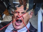 Protestors stand on an image depicting Israeli Prime Minister Benjamin Netanyahu during a gathering to protest against the US and Israel attack of Iran