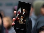 A person holds a phone with an image of Ayatollah Ali Khamenei and Mojtaba Khamenei, Iran's new Supreme Leader, as people take part in a rally for Al Quds Day on March 13, 2026 in New York City.