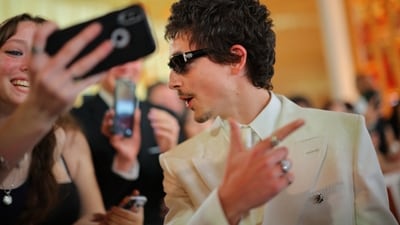 Timothee Chalamet poses with fans on the red carpet during the Oscars. (REUTERS)