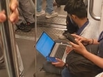 After receiving a call from his manager, a Delhi Metro passenger sat on the floor and worked on his laptop.