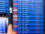 A passenger takes pictures of a flight information board at the Chhatrapati Shivaji Maharaj International Airport in Mumbai on March 1, 2026, after India's two largest private carriers, IndiGo and Air India, suspended flights to all destinations in the Middle East.
