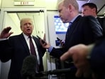 US President Donald Trump speaks to reporters aboard Air Force One on a flight back to Washington.
