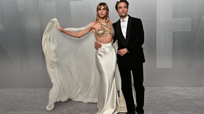 Suki Waterhouse and Robert Pattinson looked radiant as they posed together on the Vanity Fair carpet. Suki opted for a stunning white Tamara Ralph Spring/Summer 2026 gown, featuring a satin column skirt and a sculptural gold breastplate-style top, intricately desgined with swirling, sunburst metallic embellishments. A chiffon cape flowed dramatically from her shoulder. Pattinson kept it classy in black. (Evan Agostini/Invision/AP) Suki Waterhouse and Robert Pattinson looked radiant as they posed together on the Vanity Fair carpet. Suki opted for a stunning white Tamara Ralph Spring/Summer 2026 gown, featuring a satin column skirt and a sculptural gold breastplate-style top, intricately desgined with swirling, sunburst metallic embellishments. A chiffon cape flowed dramatically from her shoulder. Pattinson kept it classy in black. (Evan Agostini/Invision/AP)
