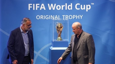 President of Iran Football Federation Mehdi Taj and Mayor of Tehran Alireza Zakani stand next to the FIFA World Cup Trophy during an unveiling ceremony in Tehran (via REUTERS)
