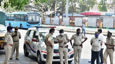 The Bengaluru police stand guard at BMTC bus stand, as coronavirus cases surge in Bengaluru, Wednesday (PTI)