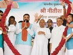 Bihar CM Nitish Kumar and Deputy CM Samrat Choudhary being garlanded during a Jan Samwad programme as part his Samriddhi Yatra in Bhagalpur on Tuesday. (HT Photo)