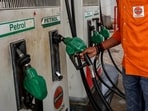 A petrol pump attendant picks up a nozzle to refuel a vehicle at an Indian Oil fuel station in Varanasi.