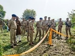 Police investigate at the site where the body of a missing 11-year-old girl was allegedly found buried in a field at the Ghatampur-Bidhnu area, Kanpur