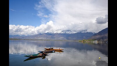 A man on a boat at Dal Lake in Srinagar on Tuesday. Weather improved across Jammu and Kashmir on Tuesday amid predictions by the meteorological centre of more rains and snowfall for the next few days which may coincide with the upcoming Eid. (ANI) A man on a boat at Dal Lake in Srinagar on Tuesday. Weather improved across Jammu and Kashmir on Tuesday amid predictions by the meteorological centre of more rains and snowfall for the next few days which may coincide with the upcoming Eid. (ANI)