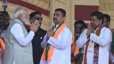 PM Narendra Modi greets BJP leaders Suvendu Adhikari and Sukanta Majumdar during a poll rally at Brigade Parade Ground in Kolkata on March 14, 2026. (Samir Jana/HT Photo)