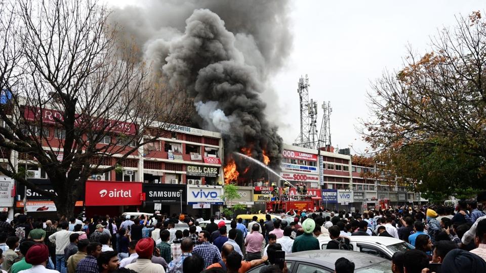 A crowd of onlookers watching firefighters dousing the flames in the Sector 22 mobile market of Chandigarh on Wednesday. (Keshav Singh/HT) A crowd of onlookers watching firefighters dousing the flames in the Sector 22 mobile market of Chandigarh on Wednesday. (Keshav Singh/HT)