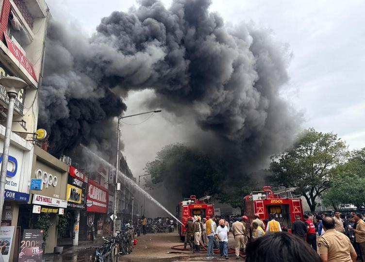 Smoke billowing from the shops on fire in the Sector 22 mobile market on Wednesday afternoon. (Ravi Kumar/HT) Smoke billowing from the shops on fire in the Sector 22 mobile market on Wednesday afternoon. (Ravi Kumar/HT)