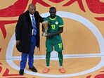 CAF President Patrice Motsepe stands next to Senegal's Sadio Mane with the Man of the Competition award after the AFCON final.