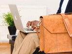 A sleek laptop briefcase bag slung across the shoulder, ready for office commutes, meetings and smooth travel with your carry-on suitcase.(Pexels)