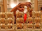 A saleswoman shows gold bangles to a customer at a jewellery showroom in Kolkata, India.