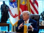 President Donald Trump holds a model of a B-2 stealth bomber as he speaks after signing an executive order in the White House