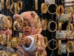 A woman along with her child shopping for bangles at a market in Srinagar on the eve of Eid-ul-Fitr on Friday. (AFP Photo)