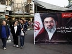People walk next to a banner with a picture of Iran's new Supreme Leader, Mojtaba Khamenei, at Tajrish Bazaar, ahead of Nowruz, the Iranian New Year, amid the US-Israeli conflict with Iran, in Tehran on March 19, 2026. 