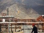 File image: An Iranian man walks along the phase 15-16 of the South Pars gas field facilities in the southern Iranian port of Assaluyeh on the shore of the Gulf on January 22, 2014