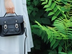 A classic satchel handbag carried through a sunny city afternoon, roomy enough for daily essentials yet compact enough for comfort.(pexels.com)