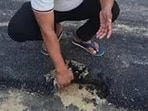 The controversy escalated when corporator Rajesh Kumar was seen removing the bitumen layer of the road with his bare hands. (Sourced)