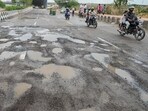 The sector road seen filled with potholes on Friday, making commuting difficult. (Parveen Kumar/HT)