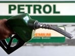 An attendant holds a petrol nozzle at a petrol pump in Siliguri.