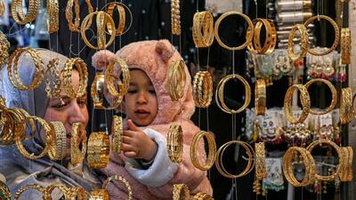 A woman along with her child shopping for bangles at a market in Srinagar on the eve of Eid-ul-Fitr on Friday. (AFP Photo) A woman along with her child shopping for bangles at a market in Srinagar on the eve of Eid-ul-Fitr on Friday. (AFP Photo)