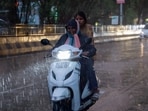 Commuters on their way amid rain, in Jalandhar on Friday. (HT Photo)