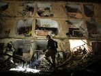 An Israeli soldier uses a torch to inspect the damage after Iranian missile barrages struck Dimona.