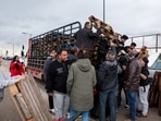 Displaced people receive wooden pallets, used to build makeshift shelters, amid rainy weather, during Eid al-Fitr celebrations in Beirut