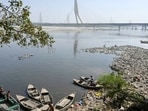A fisherman catches fish in the Yamuna River near Signature Tower, in New Delhi.