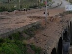 People inspect a crater following an Israeli airstrike that hit the Qasmiyeh Bridge near the coastal city of Tyre, Lebanon.