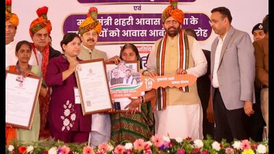 Haryana chief minister Nayab Singh Saini hands over house keys and allotment letters to beneficiaries of a housing scheme in Gurugram on Sunday. (Parveen Kumar/HT) Haryana chief minister Nayab Singh Saini hands over house keys and allotment letters to beneficiaries of a housing scheme in Gurugram on Sunday. (Parveen Kumar/HT)