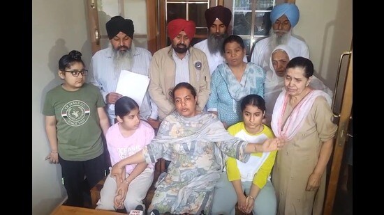 Upinder Kaur, wife of late Punjab State Warehousing Corporation (PSWC) district manager Gagandeep Singh Randhawa, addresses a press conference along with her children and family members at their residence.in, Amritsar, on Sunday, March 22,2026. (Sameer Sehgal/HT)