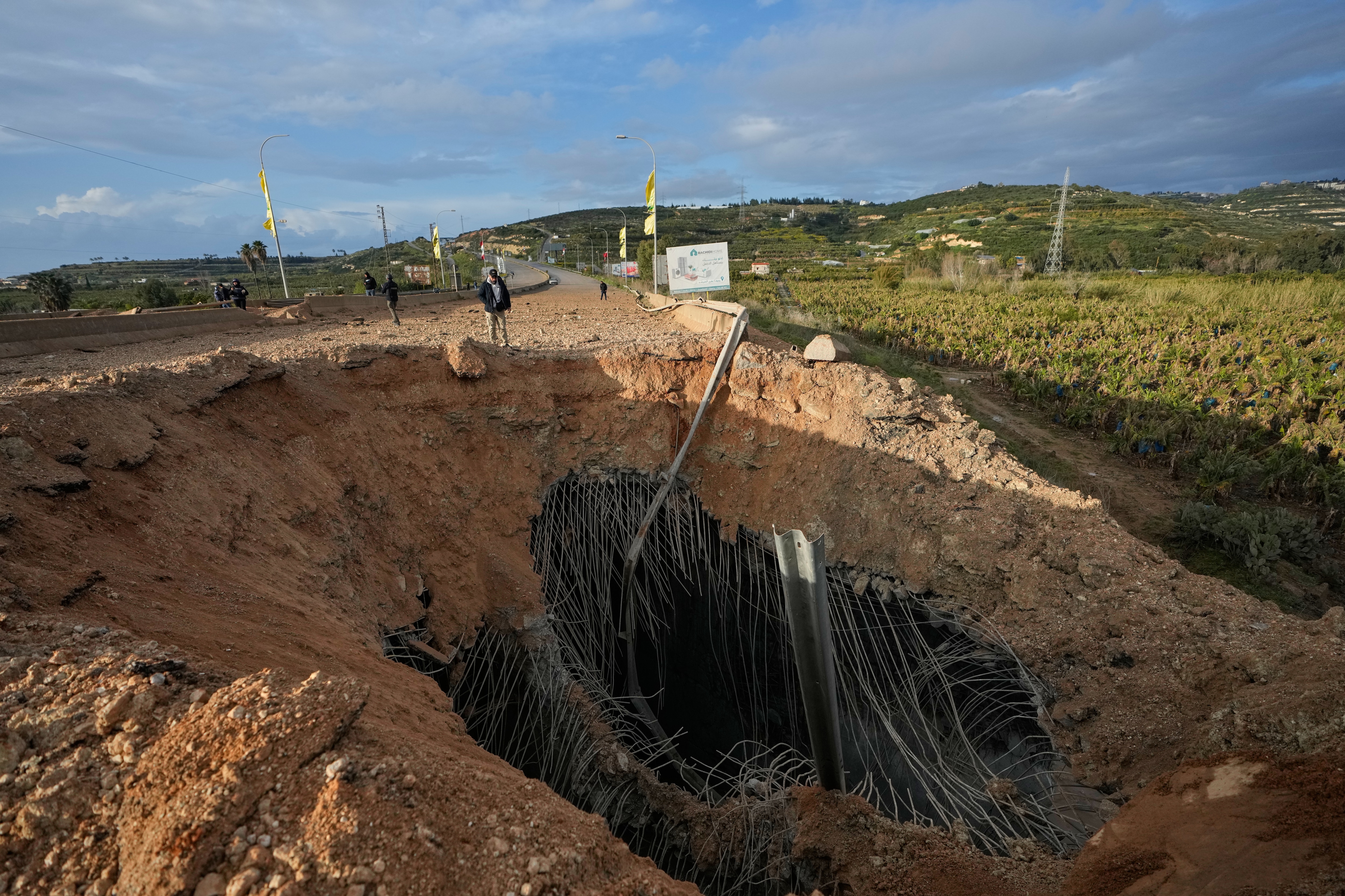 People inspect a crater following an Israeli airstrike that hit the Qasmiyeh Bridge near the coastal city of Tyre, Lebanon. (AP) People inspect a crater following an Israeli airstrike that hit the Qasmiyeh Bridge near the coastal city of Tyre, Lebanon. (AP)