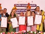CM Saini gives house keys and allotment letters to beneficiaries of the CM Urban Housing Scheme on Sunday. (Parveen Kumar/HT)