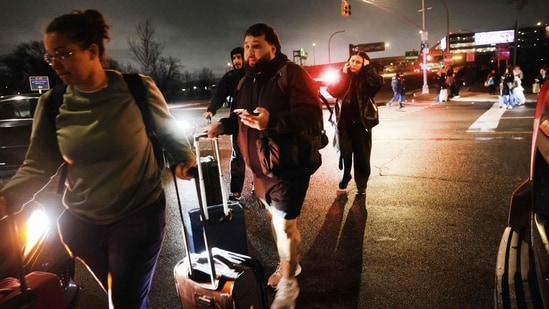 Travellers look for rides after LaGuardia Airport was closed following a collision between an Air Canada Express plane and a fire truck on the tarmac on March 23, 2026 in New York City.(Getty Images via AFP)