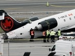 Personnel of the National Transportation Safety Board (NTSB) inspect the wreckage of an Air Canada Express jet that collided with a fire truck at New York's LaGuardia Airport in Queens, New York, U.S., March 23, 2026. REUTERS/Eduardo Munoz