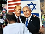 A member of the Iranian community in Australia holds a placard in support of US President Donald Trump and Israeli Prime Minister Benjamin Netanyahu during a rally 
