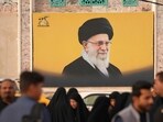 Iraqi Shias walk past a picture of Iran's slain supreme leader Ayatollah Ali Khamenei in Iraq's central holy city of Najaf.