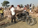 Local residents carrying potatoes dumped along with the cold store debris in Phaphamau Kachchar area on Tuesday. (ANIL KUMAR MAURYA/HT PHOTO)