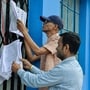 Siliguri, Mar 02 (ANI): Voters check their names in the updated voter list hanging up at the Siliguri Indoor Stadium premises, in Siliguri on Monday. (@drmohanoffice51 X/ANI Photo)