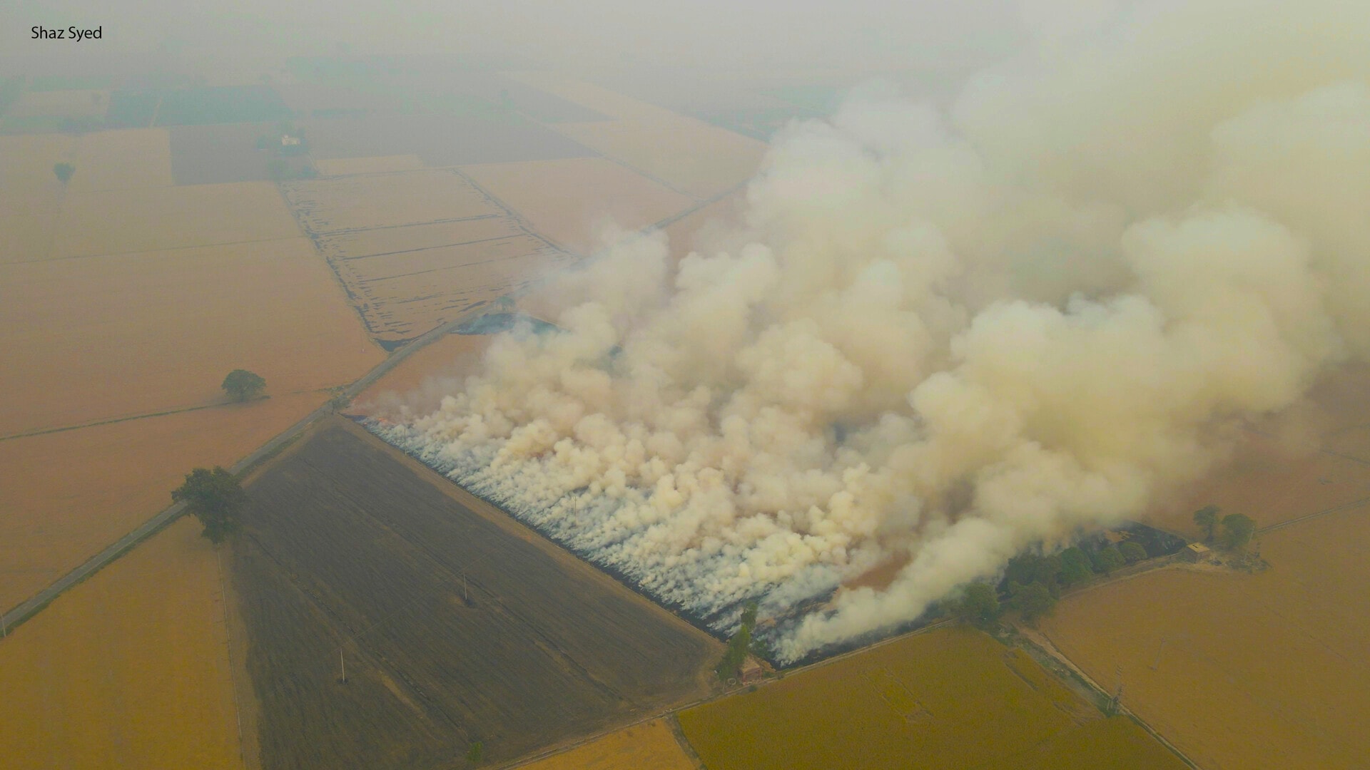 Smoke billows from the fields as farmers burn stubble in the harvest season. Smoke billows from the fields as farmers burn stubble in the harvest season.