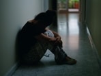 Middle age hispanic woman suffering for domestic violence with bruise on eyes sitting on floor at home