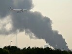 Middle East war news highlights: File photo of an Emirates aircraft flying past plumes of smoke from an ongoing fire in UAE.