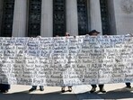 Parents and relatives hold a banner listing victims� names outside Los Angeles Superior Court after the social media trial verdict, on March 25, 2026. A Los Angeles jury on March 25 found Meta and YouTube liable for harming a young woman through the addictive design of their social media platforms and ordered the companies to pay $3 million in damages. The decision delivering a landmark verdict that could reshape how the tech industry faces legal accountability for the mental health of young users. (Photo by Frederic J. Brown / AFP)